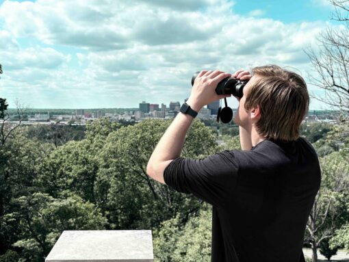 Man viewing a city landscape with the Oberwerk 10x50 Deluxe binocular