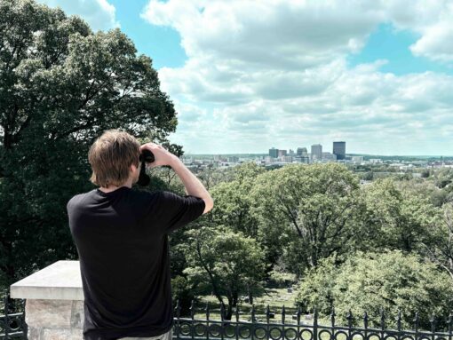 Man looking out at a city with the Oberwerk 8x42 Deluxe binocular
