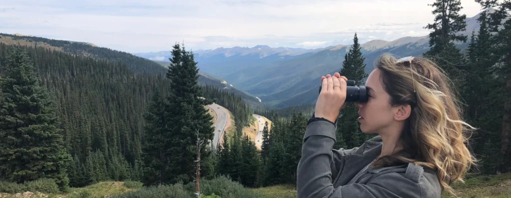 Oberwerk Sport HD II binoculars used by a woman in the mountains